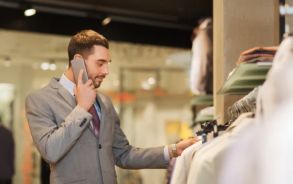 Homem feliz chamando no smartphone na loja de roupas — Fotografia de Stock