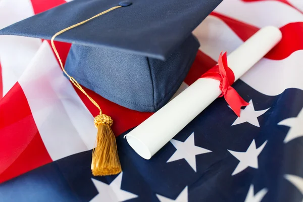 学士帽子とアメリカの国旗に卒業証書 — ストック写真