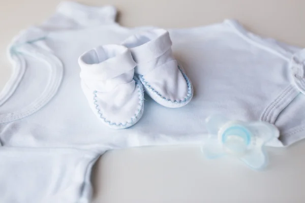 Primer plano de la ropa de los niños del bebé para el recién nacido en la mesa — Foto de Stock