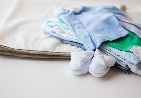 Primer plano de la ropa de los niños del bebé para el recién nacido en la mesa —  Fotos de Stock