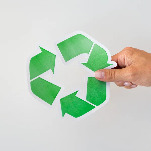 Fechar a mão segurando símbolo de reciclagem verde — Fotografia de Stock