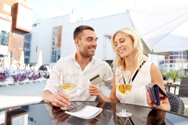 Casal feliz com carteira pagar conta no restaurante — Fotografia de Stock