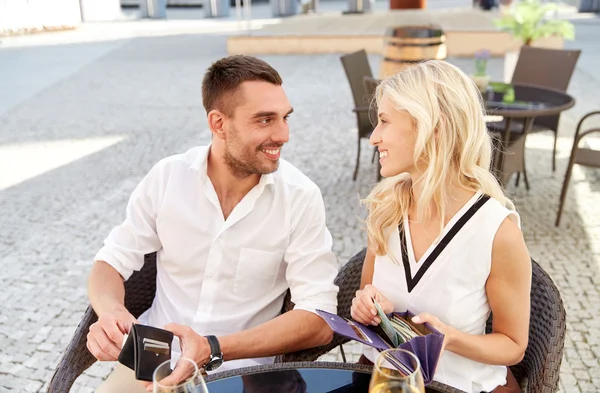 Happy couple with wallet paying bill at restaurant — Stock Photo, Image