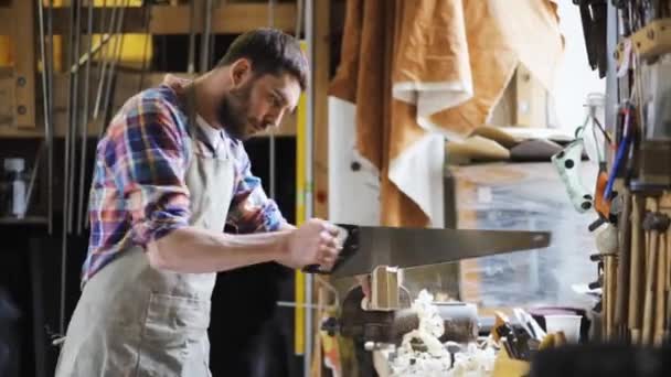 Schreiner arbeitet in Werkstatt mit Säge und Holz — Stockvideo