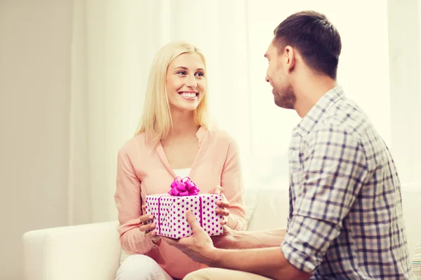 Homem feliz dando mulher caixa de presente em casa — Fotografia de Stock