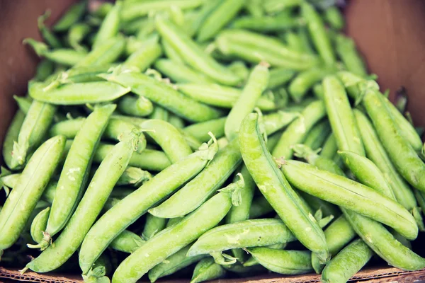 Primer plano de guisantes verdes en caja en el mercado callejero —  Fotos de Stock