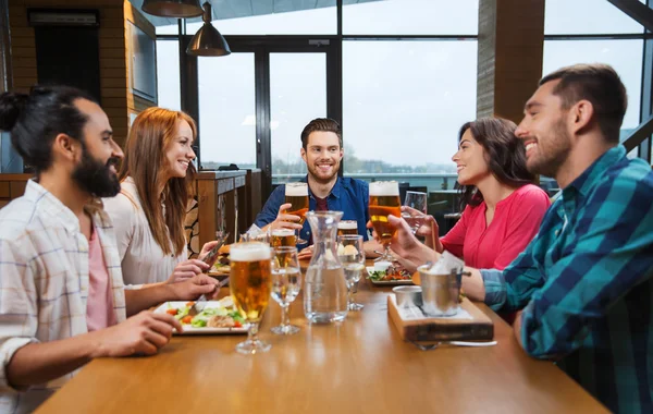 Amigos jantar e beber cerveja no restaurante — Fotografia de Stock