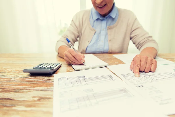 Senior femme avec papiers et calculatrice à la maison — Photo