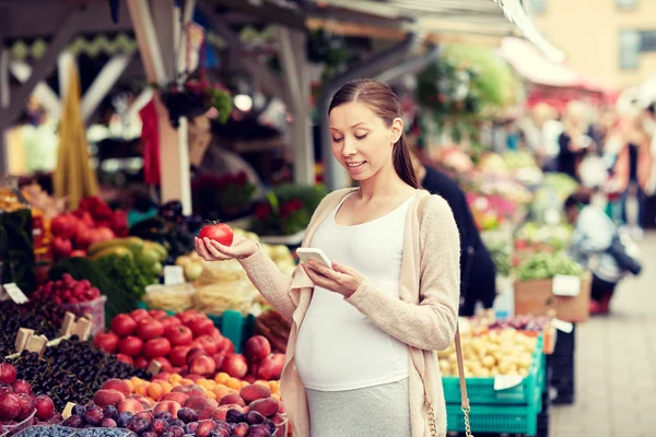 Terhes nő smartphone-on utcai piac — Stock Fotó