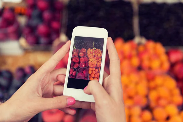 Handen met smartphone foto van vruchten — Stockfoto