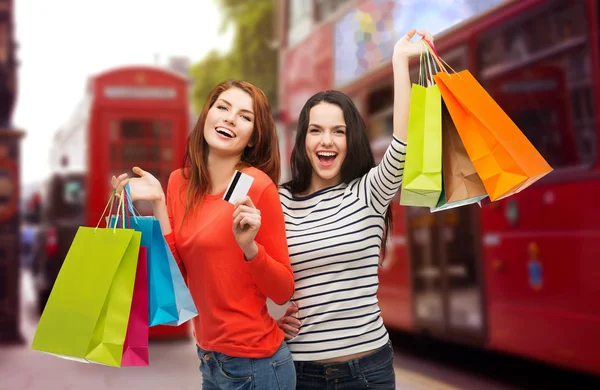 Teenage girls with shopping bags and credit card — Stock Photo, Image