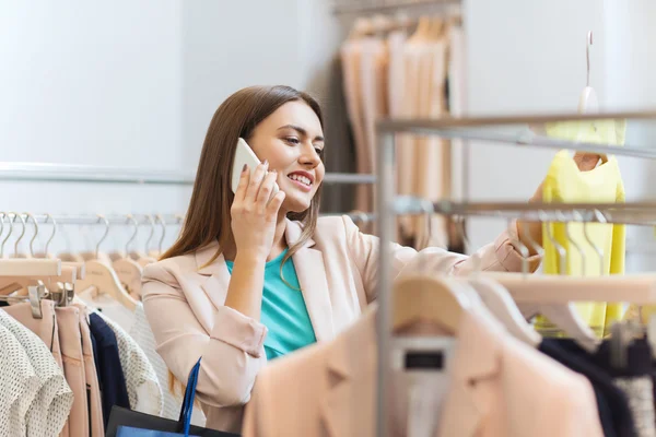 Kobieta, wzywając smartphone w sklepie odzieżowym — Zdjęcie stockowe