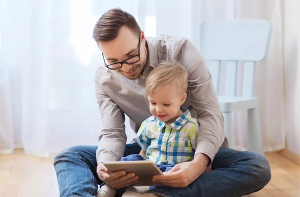 Pai e filho com tablet pc jogando em casa — Fotografia de Stock