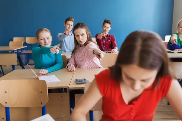 Schüler tratschen in der Schule hinter Klassenkameraden — Stockfoto