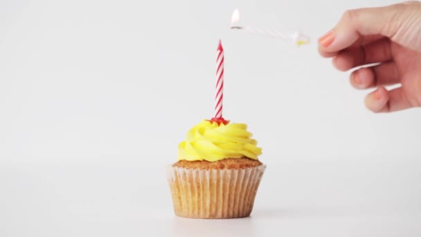 Woman with lighting candle on birthday cupcake — 图库视频影像