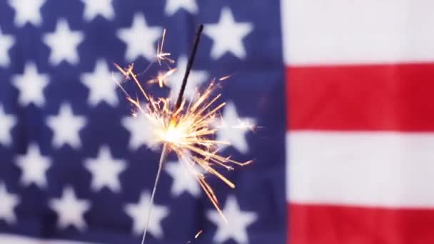 Close up van sparkler branden over Amerikaanse vlag — Stockvideo