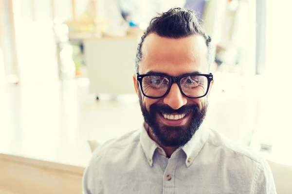 Uomo sorridente con occhiali e barba all'ufficio — Foto Stock