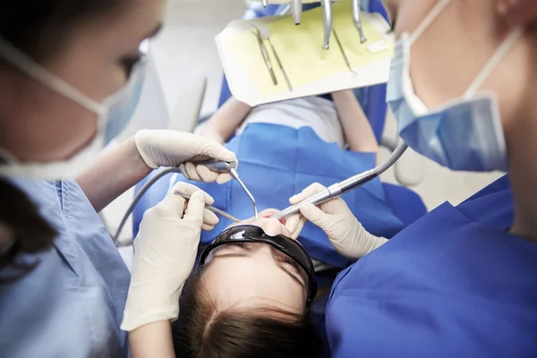 Dentistes féminines traitant les dents de fille patient — Photo