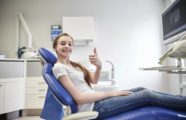 Menina paciente feliz mostrando polegares para cima na clínica — Fotografia de Stock