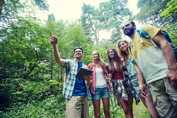 Amici felici con zaini e tablet pc trekking — Foto Stock