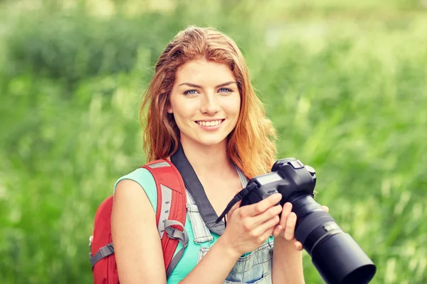 Happy woman with backpack and camera outdoors — Stock Photo, Image