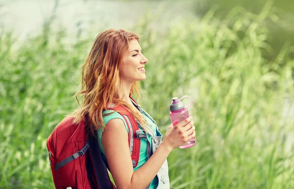 Woman with backpack and bottle of water hiking — Stock Photo, Image