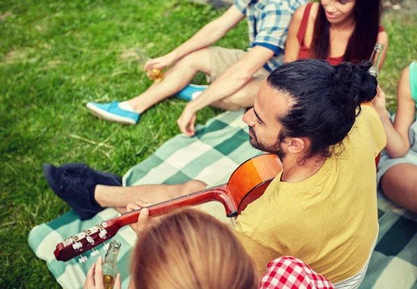 Щасливий чоловік з друзями грає на гітарі в кемпінгу — стокове фото