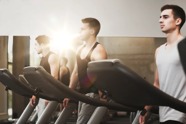 Groep mannen uitoefenen op loopband in de sportschool — Stockfoto