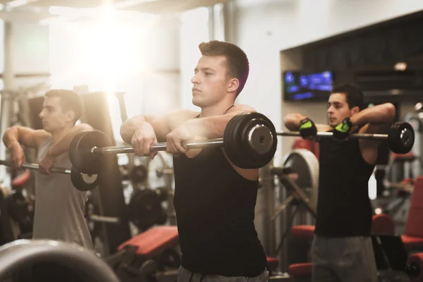 Grupo de hombres con barras en el gimnasio — Foto de Stock