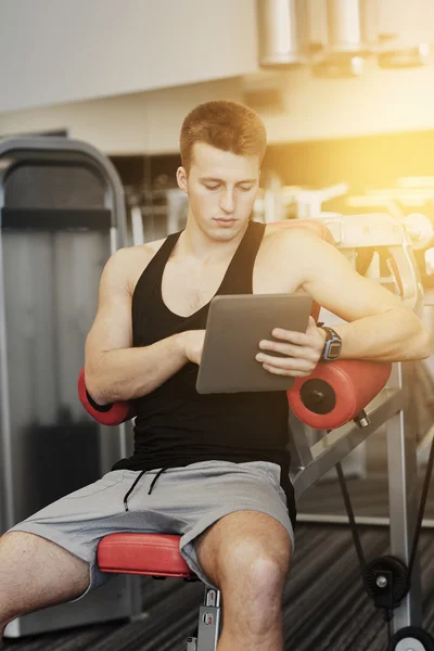 Hombre joven con tablet PC en el gimnasio — Foto de Stock