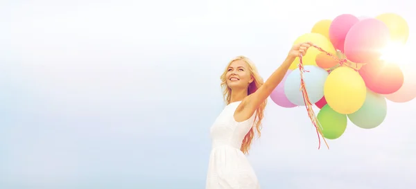 Donna sorridente con palloncini colorati all'esterno — Foto Stock