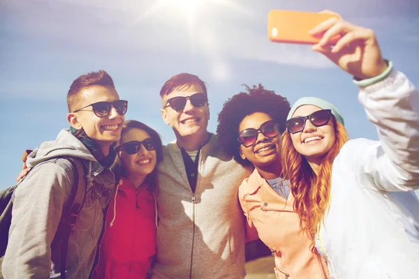 Uśmiechnięty znajomych przy selfie z smartphone — Zdjęcie stockowe