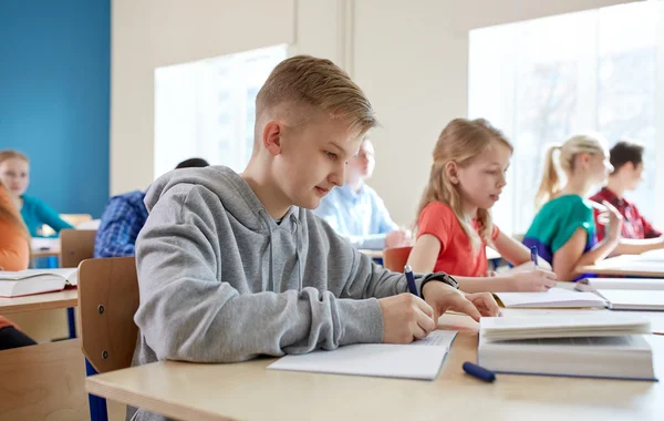 Groupe d'étudiants avec des livres écrit test scolaire — Photo