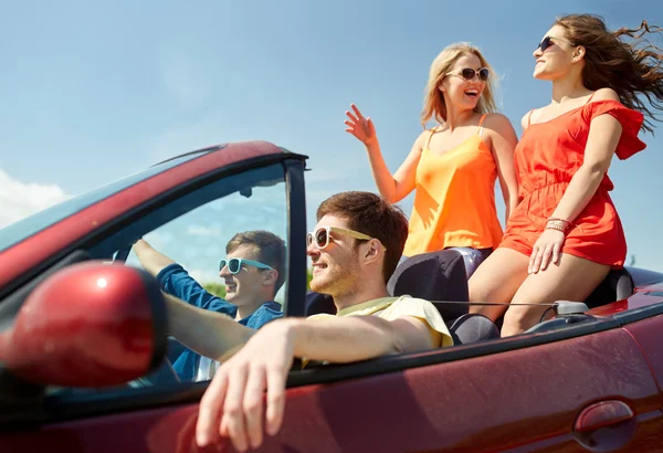 Amigos felizes dirigindo em carro cabriolet — Fotografia de Stock