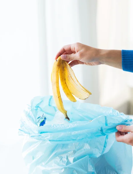 Primer plano de la mano poner desperdicio de alimentos a la bolsa de basura — Foto de Stock