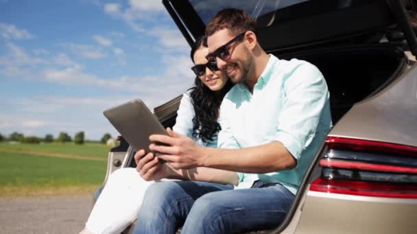 Casal feliz com tablet pc no porta-malas carro hatchback 20 — Vídeo de Stock