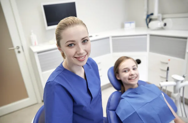 Mutlu kadın dişçi klinikte hasta kızla — Stok fotoğraf