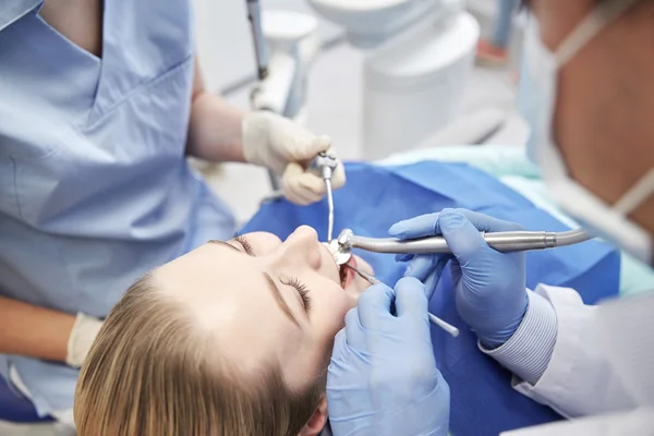 Primer plano del dentista que trata los dientes femeninos del paciente — Foto de Stock