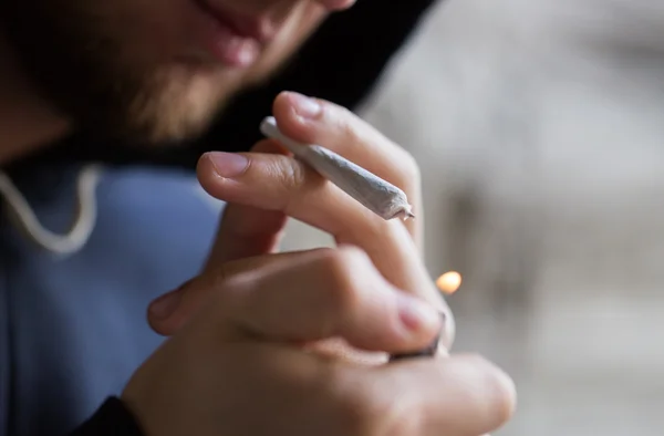 Close up of addict lighting up marijuana joint — Stock Photo, Image