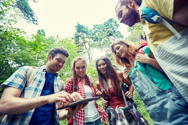 Happy friends with backpacks and tablet pc hiking — Stock Photo, Image