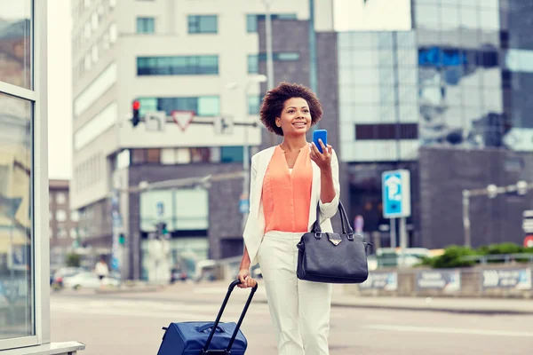 Mujer africana feliz con bolsa de viaje y teléfono inteligente —  Fotos de Stock