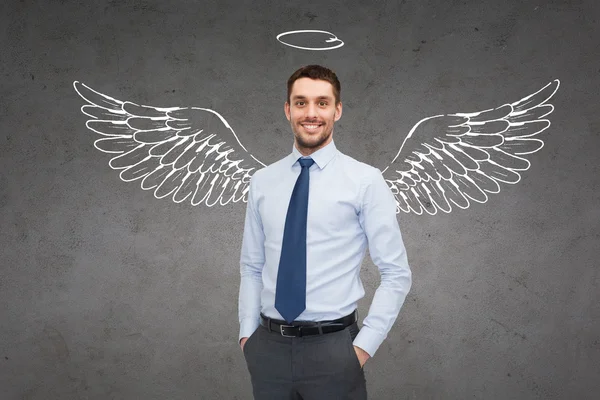 Smiling businessman with angel wings and nimbus — Stock Photo, Image