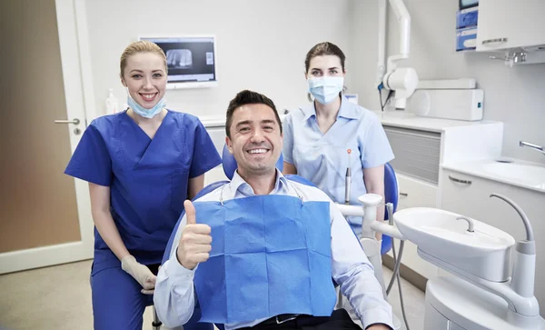 Ευτυχισμένη γυναίκα Οδοντίατροι με άνδρα ασθενή στην κλινική — Φωτογραφία Αρχείου