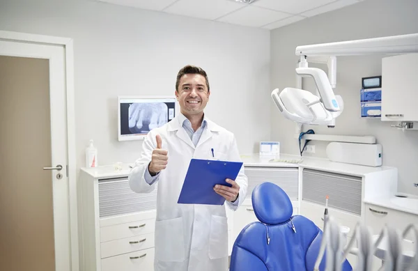 Happy male dentist showing thumbs up at clinic — Stock Photo, Image