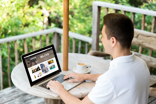Primer plano del hombre con el ordenador portátil blogging en la terraza —  Fotos de Stock