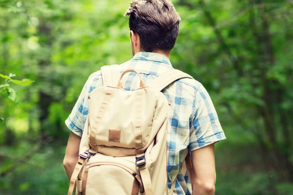 Ung man med ryggsäck vandring i skogen — Stockfoto