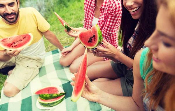 Happy friends eating watermelon at camping — Stock Photo, Image