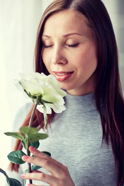 Mulher feliz cheirando grande rosa branca em casa — Fotografia de Stock