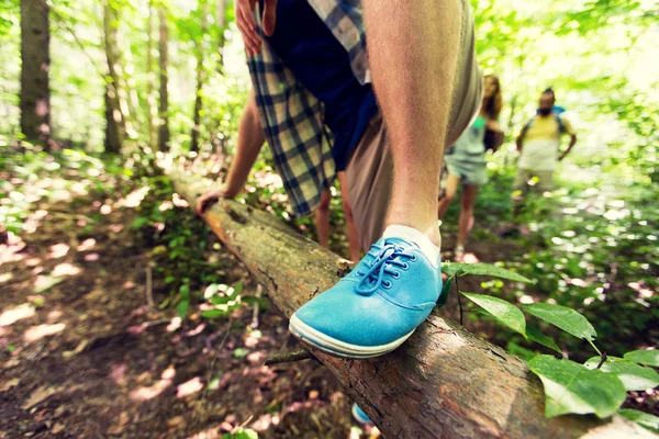 Nahaufnahme eines Mannes, der im Wald über Baumstamm klettert — Stockfoto