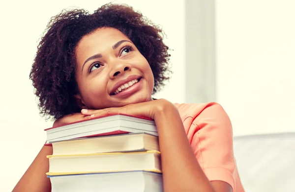 Chica estudiante africana feliz con libros en casa —  Fotos de Stock